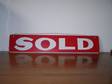 Vintage metal SOLD sign in red with white lettering.
